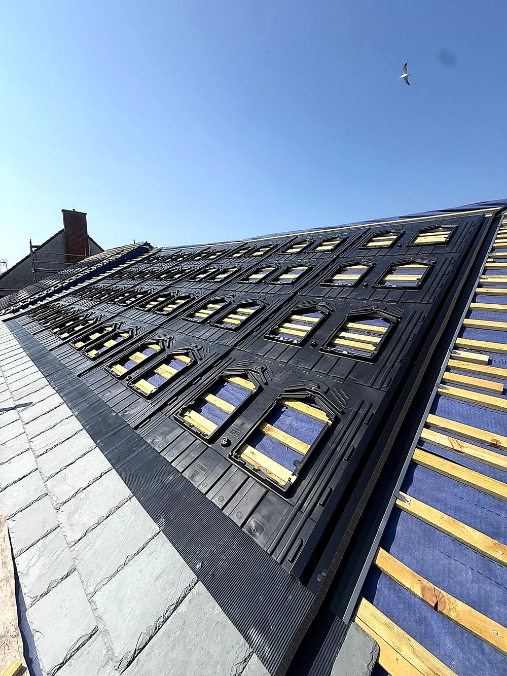 Close view of the mounting trays and interlocking flashing where the array meets the slate course