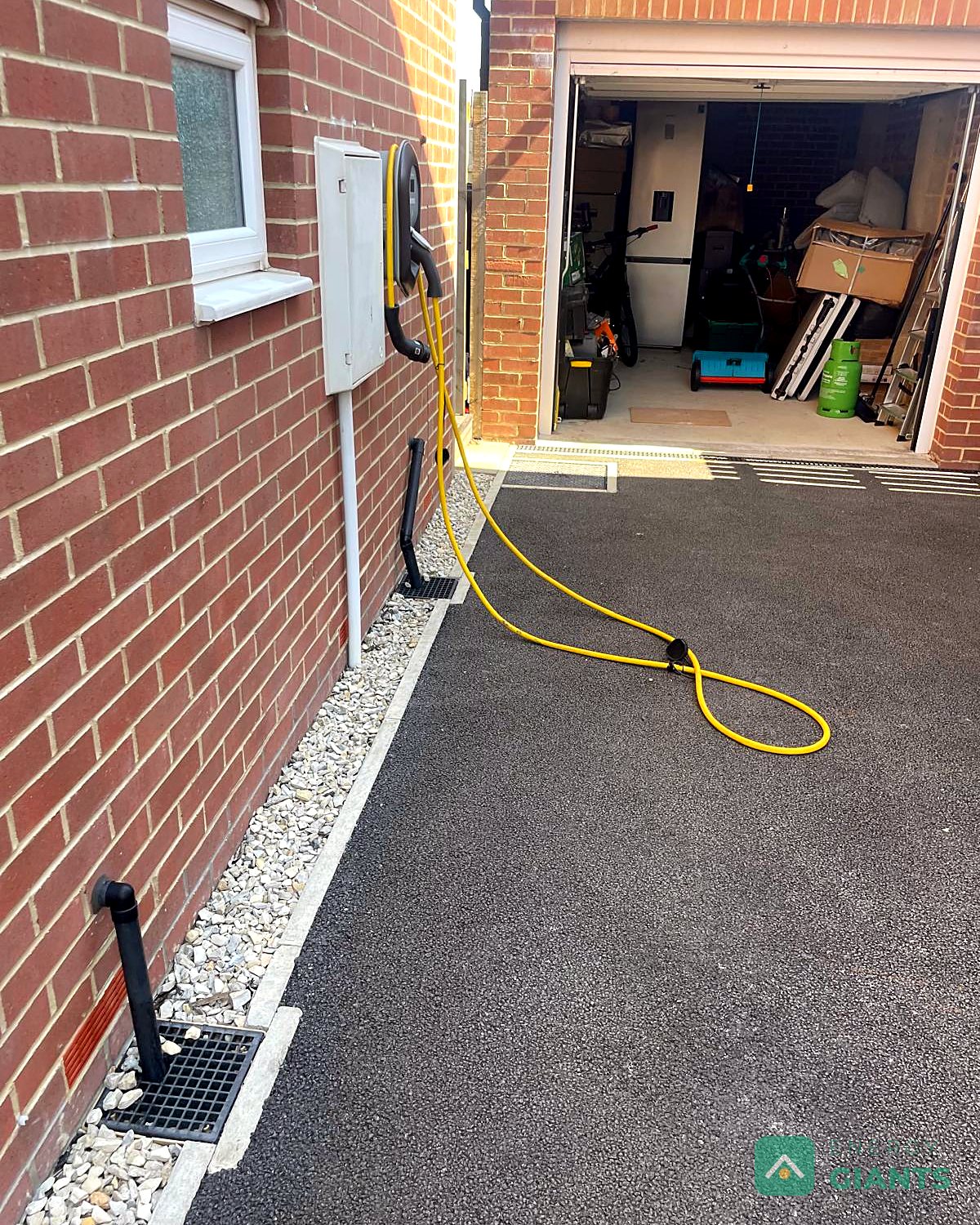 The side of the house before the install, with the meter box and an existing car charger on the wall