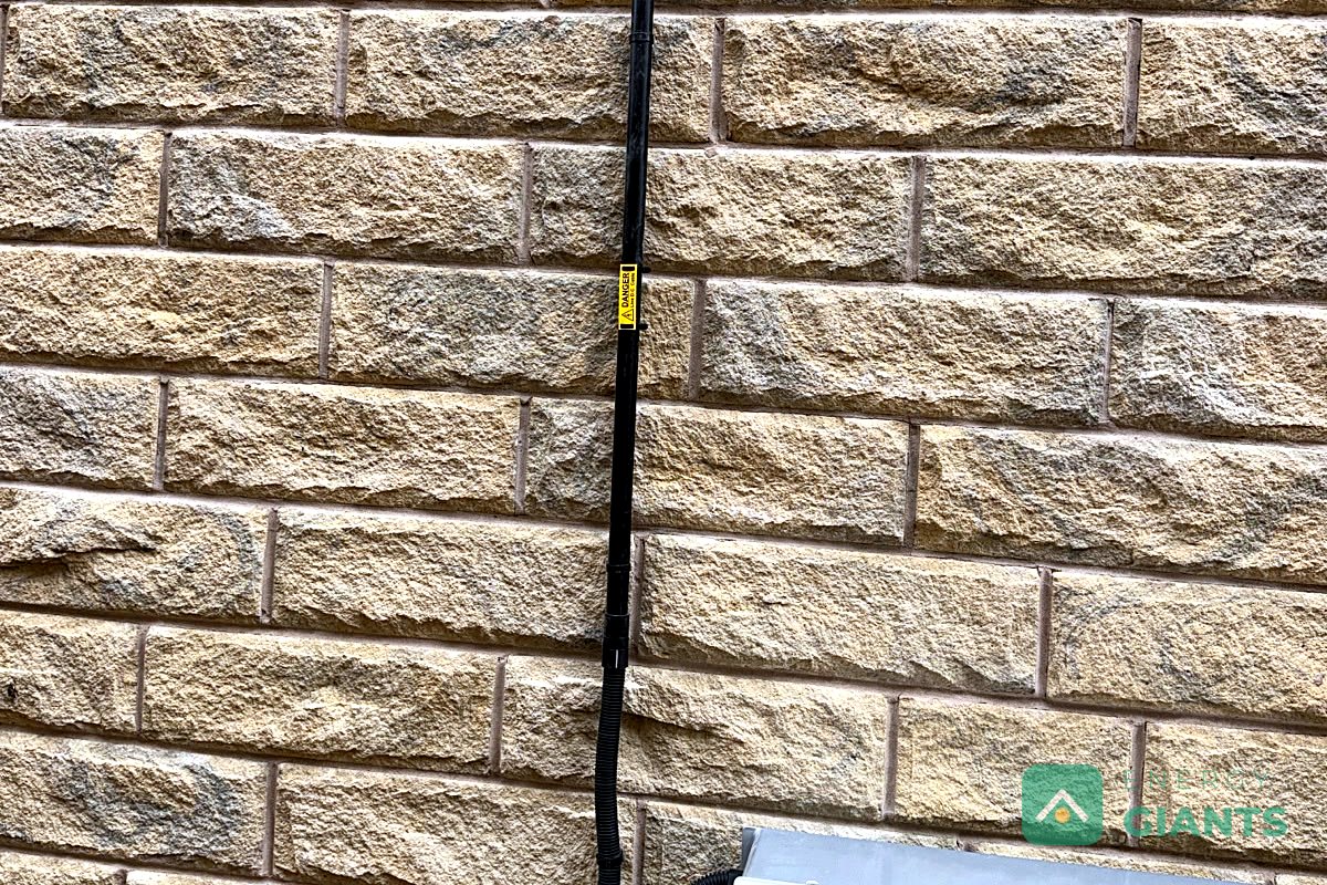 The Tesla Powerwall 3 on the stone wall of the house