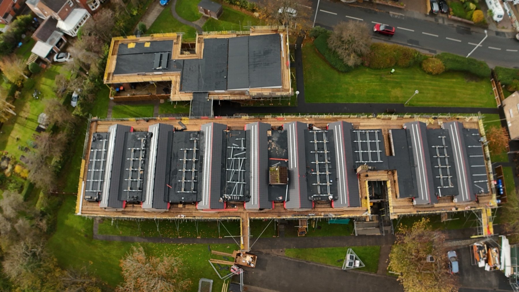 Torentum Court from above in October 2025, scaffold along the block and the new black membrane down on the flat roofs with work continuing on top