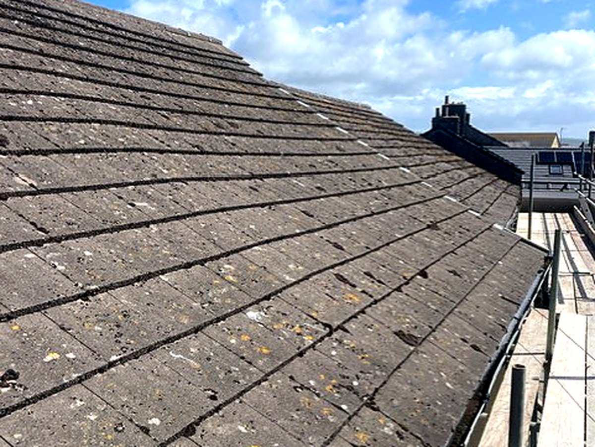 The same roof in May, worn dark slate before the covering was stripped