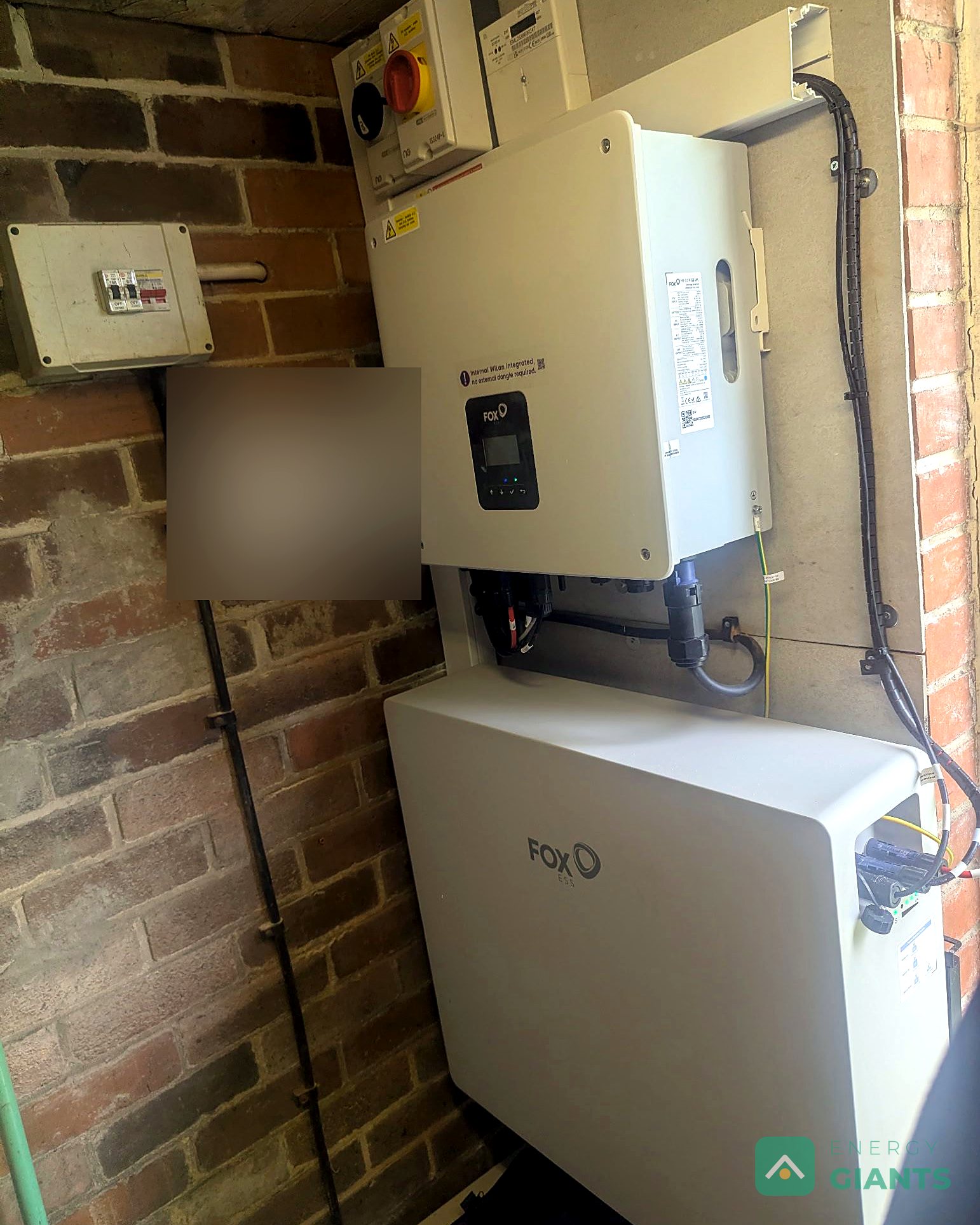 The Fox ESS inverter and battery mounted neatly on the wall of a brick outbuilding