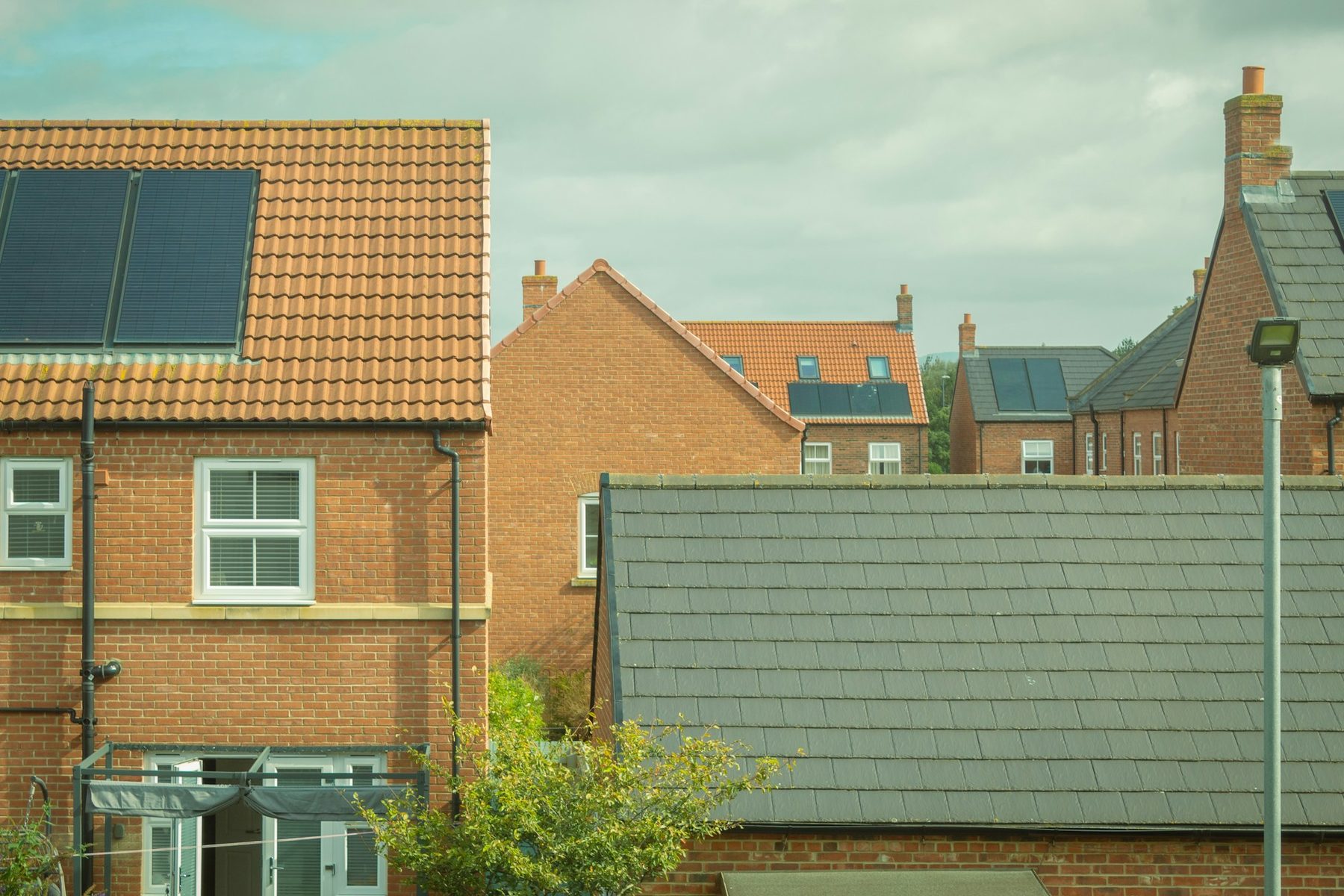 Brick homes with solar panels on the roofs. Illustrative image