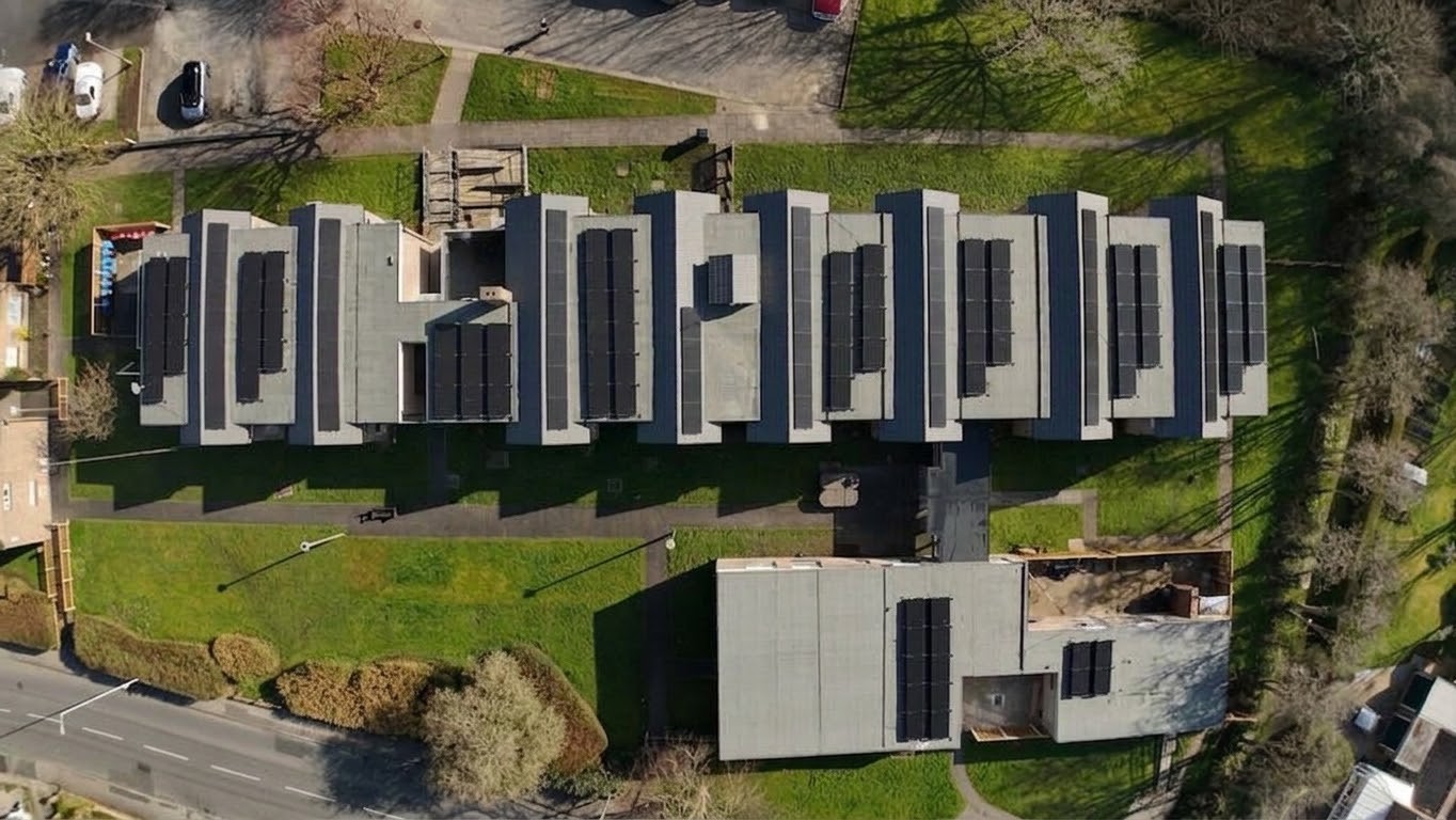 Torentum Court from above in March 2026: the long main block with its new black flat roofs, the communal building and the surrounding gardens