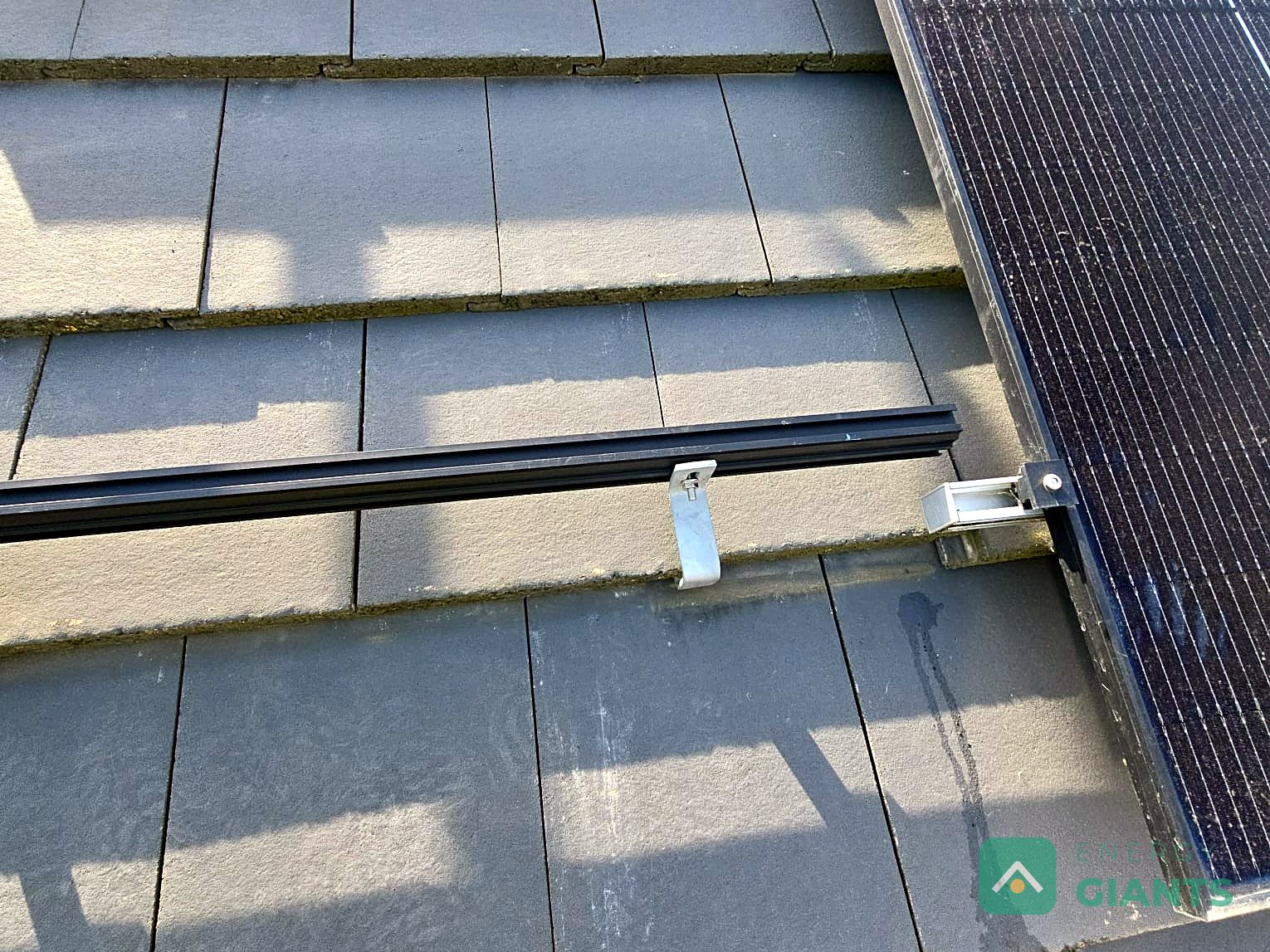 A roof hook and mounting rail fixed through the tiles