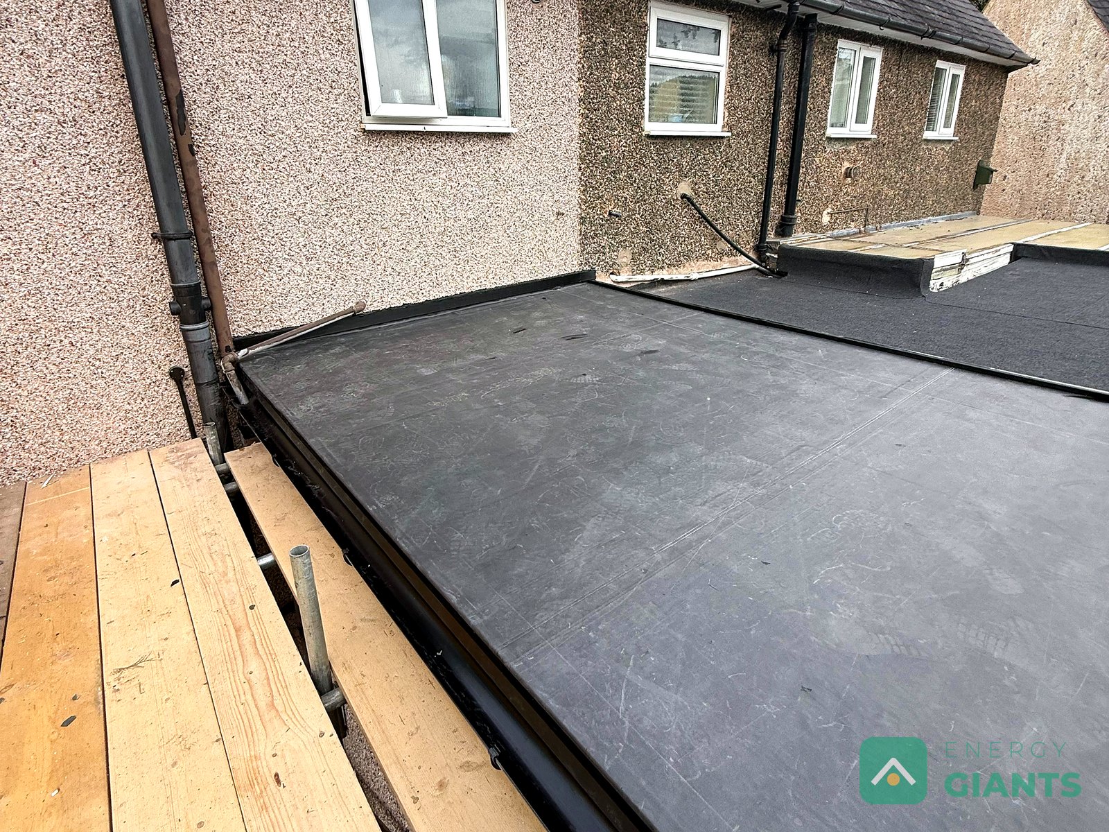 The finished EPDM membrane on the rear extension roof in Llanrwst, dressed up to the rendered wall of the house