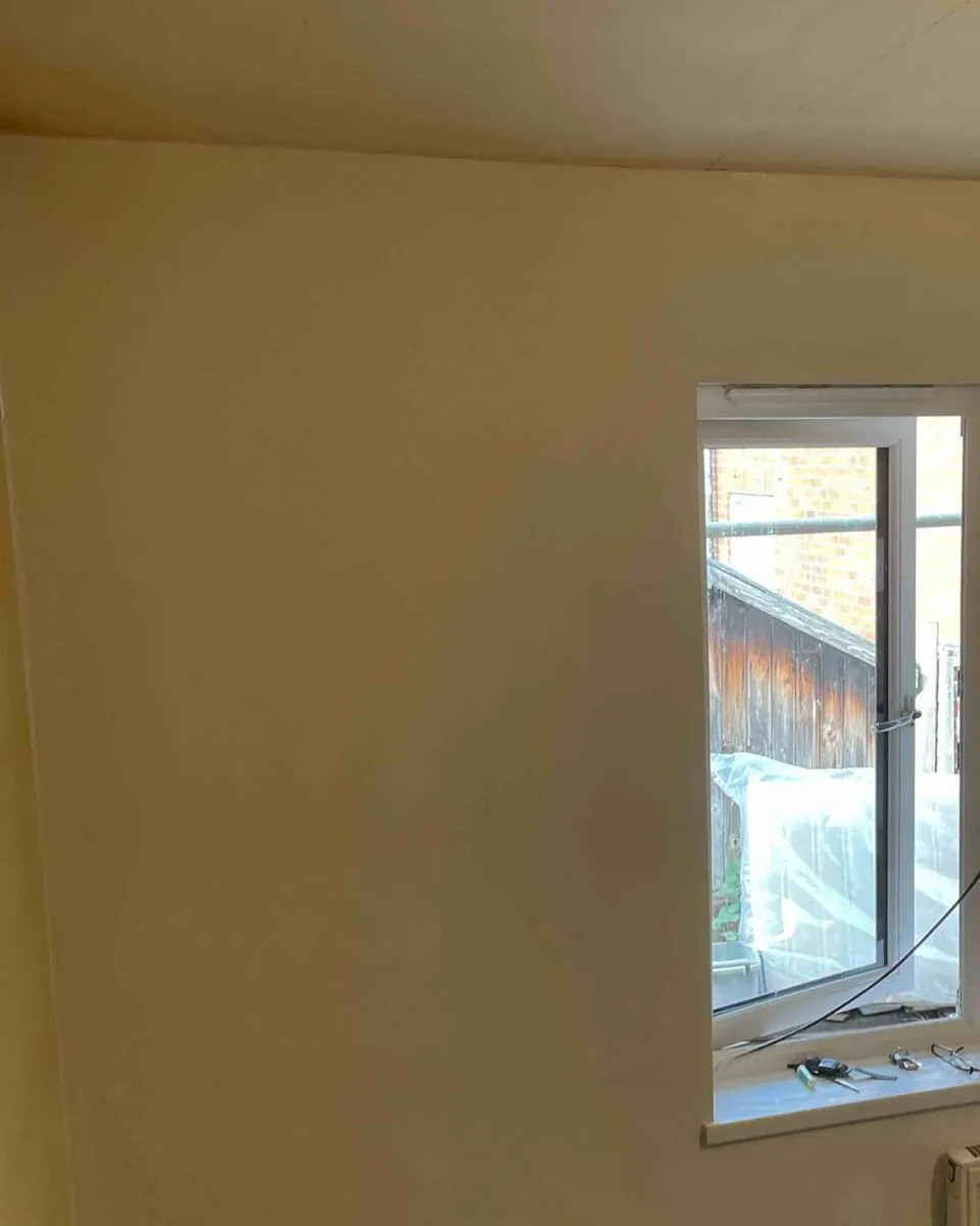 The finished bedroom wall, skimmed smooth with the window and sill back in place