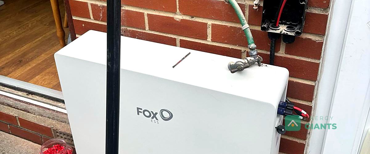 A Fox ESS battery fitted on the rear wall of a brick house in Tingley