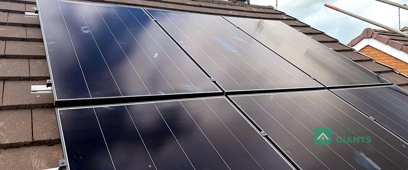 The rear of a semi detached house in Ashton-in-Makerfield with black Aiko solar panels on the roof