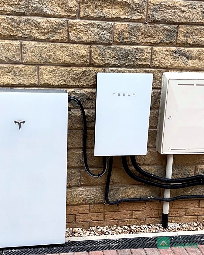 A Tesla Powerwall 3 and Backup Gateway fitted neatly on a stone wall