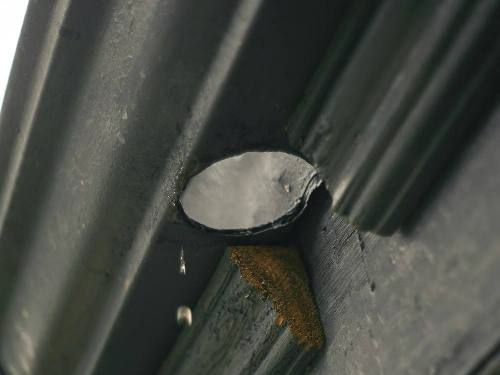 Close up of a metal gutter outlet leading to the downpipe