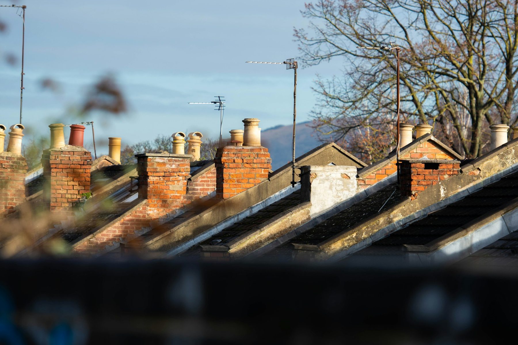 Chimneys and rooftops along a terraced street. Illustrative image