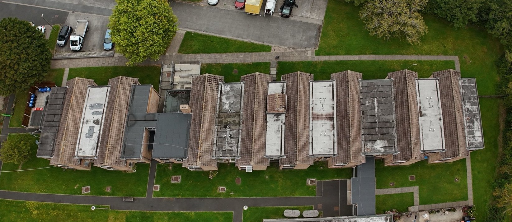 The main block at Torentum Court from above in August 2025, the flat roofs between the pitched sections patched and faded
