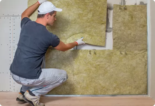 Blown cavity wall insulation being injected through a drilled point in an external wall. Illustrative image
