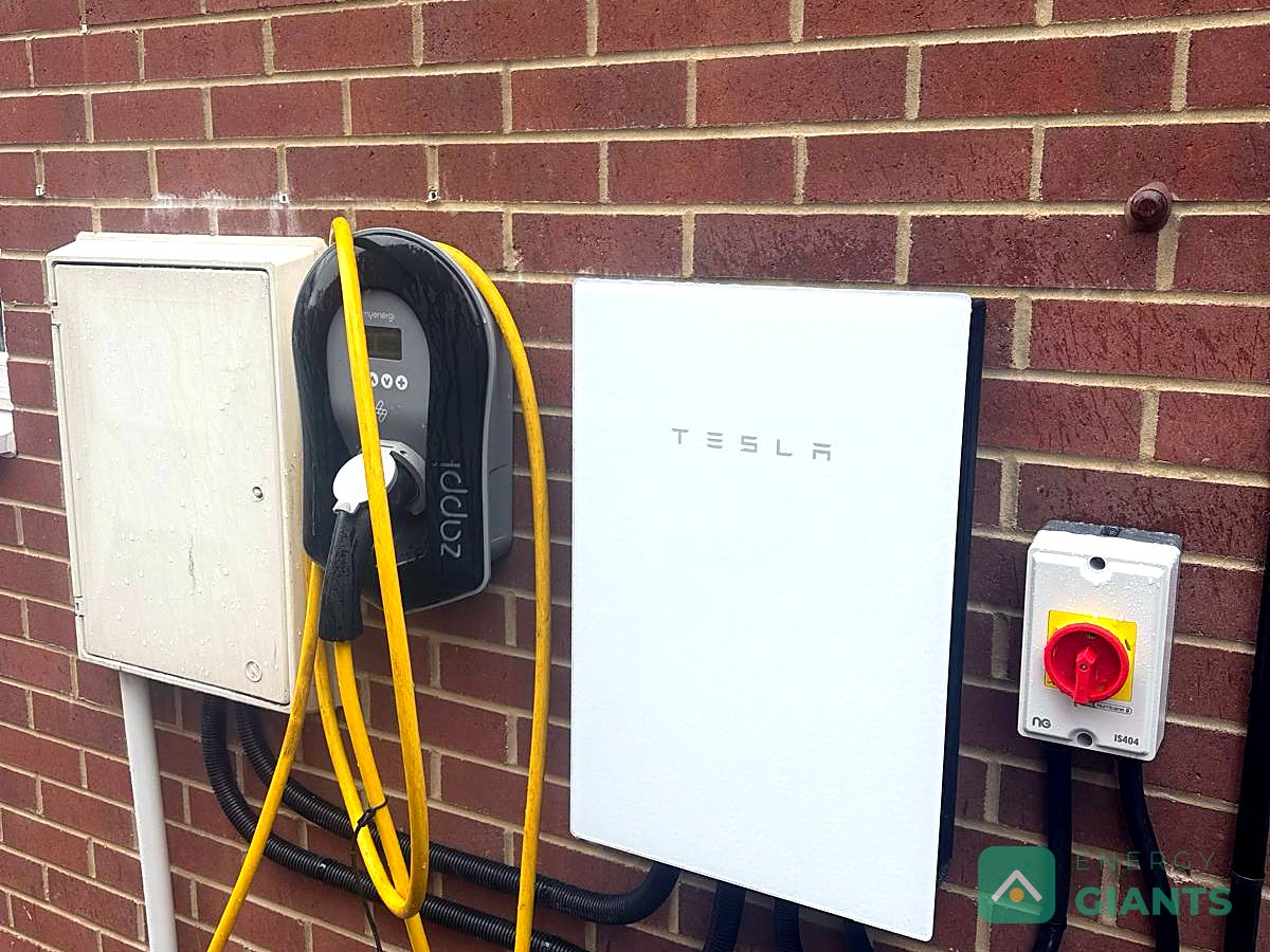 A Tesla Powerwall 3 on the brick wall of a house in Morley, beside a car charger