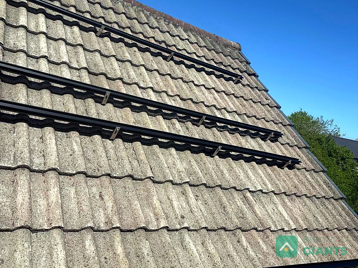 Mounting rails fixed to the tiled roof beside the chimney